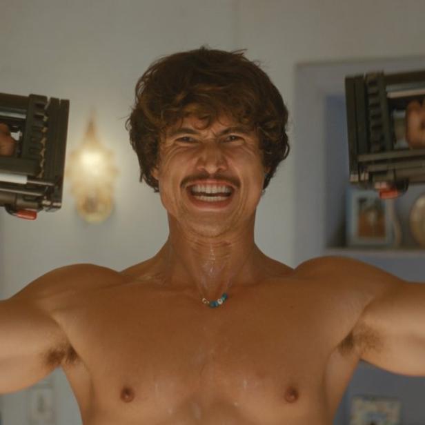 Mann mit muskulösem nackten Oberkörper macht daheim Krafttraining