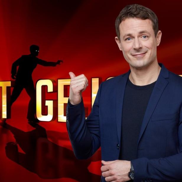 Alexander Bommes vor dem "Gefragt - Gejagt"-Logo