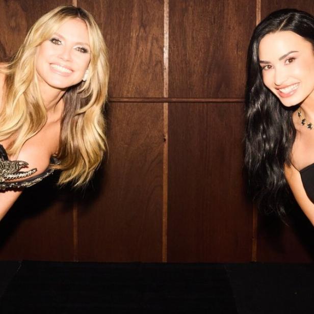 Heidi Klum und Demi Lovato blicken aus einer Aufzugskabine