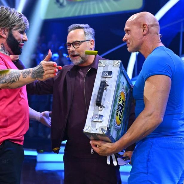 Harald Glööckler beglückwünscht den Geldkoffer haltenden Thorsten Legat