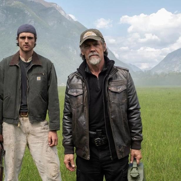 Jacob Elordi und Josh Brolin stehen auf großer Wiese mit Bergen im Hintergrund