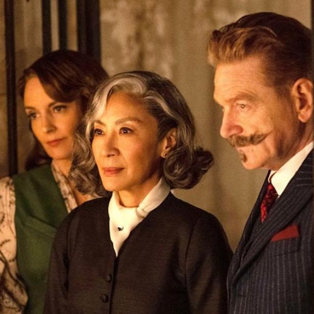 Kenneth Branagh als Hercule Poirot neben Tina Fey und Michelle Yeoh