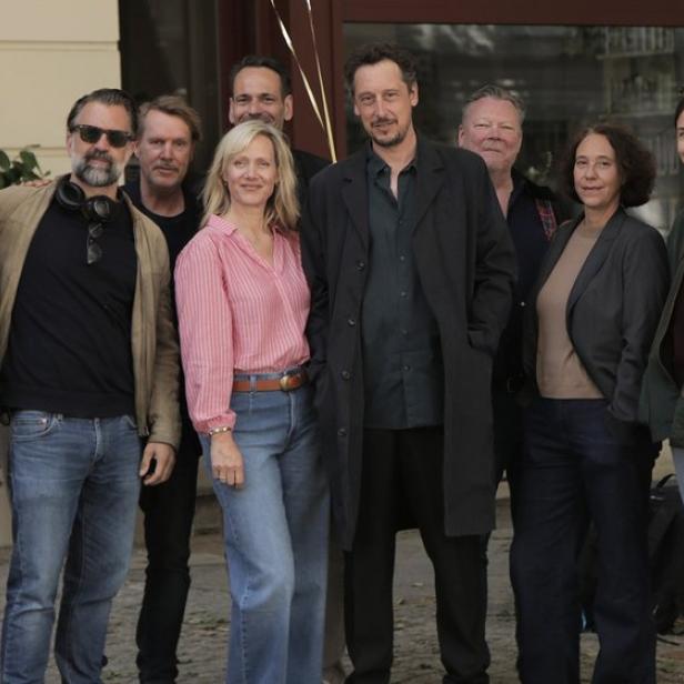 Eine Gruppe von zehn Personen posiert im Freien für ein Gruppenfoto.
