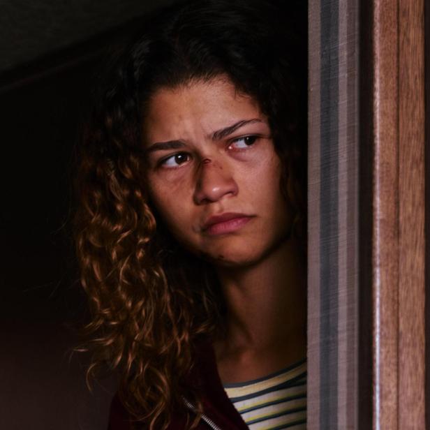 Zendaya in ihrer Euphoria Rolle als Rue blickt finster hinter einem Türstock hervor