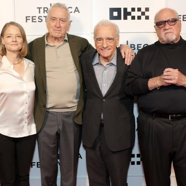 Jodie Foster, Robert De Niro, Martin Scorsese und ein weiterer Mann posieren vor einer Wand mit dem Logo des Tribeca Festivals.