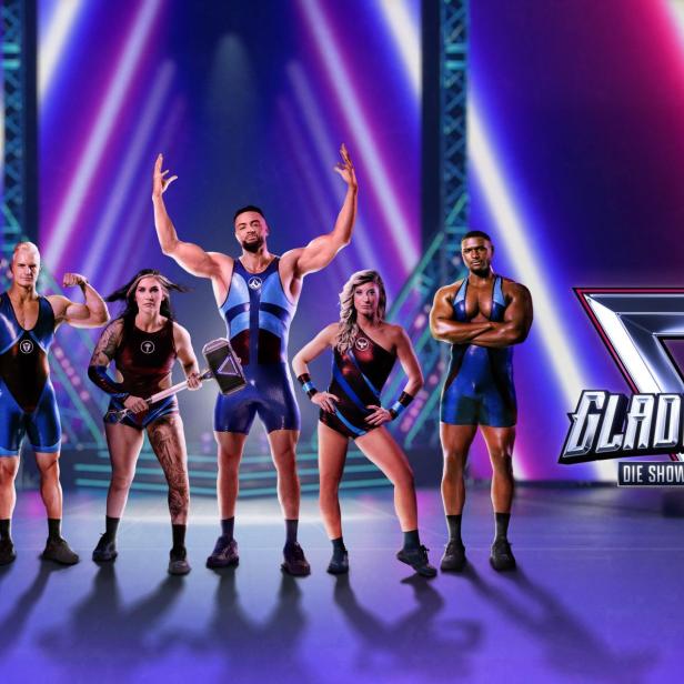 Sechs Athleten in Wrestling-Outfits posieren vor bunten Scheinwerfern, daneben steht das Logo „Gladiators – Die Show der Giganten“.