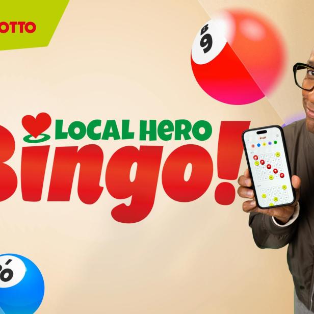 Ein Mann mit Brille hält ein Smartphone und WestLotto-Bingoscheine vor dem Schriftzug „Local Hero Bingo!“ in die Kamera.