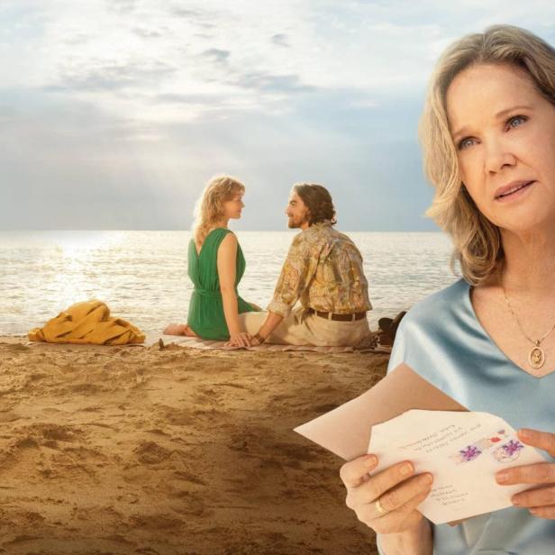 Im Vordergrund hält eine nachdenkliche ältere Frau einen Brief, während im Hintergrund ein junges Paar am Strand sitzt.